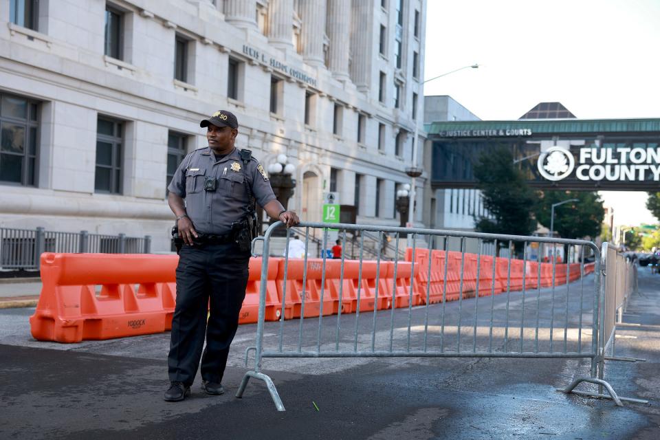 A Fulton County Sheriff officer stands near barricades setup in front of the Fulton County Courthouse on Aug.7, 2023 in Atlanta. The heightened security is in place as Fulton County District Attorney Fani Willis is expected to make an announcement soon about a possible grand jury indictment in her investigation into former President Donald Trump and his Republican allies alleged attempt to overturn the 2020 election in the state.