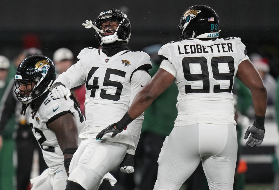 Jacksonville Jaguars linebacker K'Lavon Chaisson (45) celebrates with defensive tackle DaVon Hamilton (52) and defensive end Jeremiah Ledbetter (99) after a sack against the New York Jets during the third quarter of an NFL football game, Thursday, Dec. 22, 2022, in East Rutherford, N.J. (AP Photo/Seth Wenig)