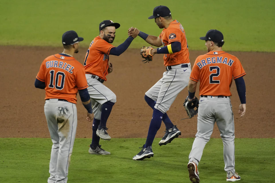 Houston Astros Carlos Correa (1) celebrates with Jose Altuve after winning Game 6 of a baseball American League Championship Series, Friday, Oct. 16, 2020, in San Diego. The Astros defeated the Rays 7-4 to tie the series 3-3. (AP Photo/Ashley Landis)