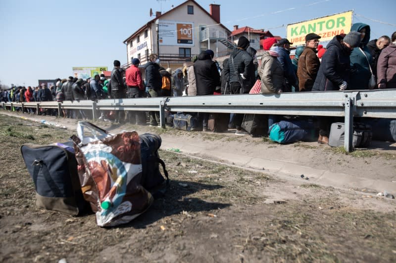 People queue to cross to Ukraine at the border crossing in Dorohusk