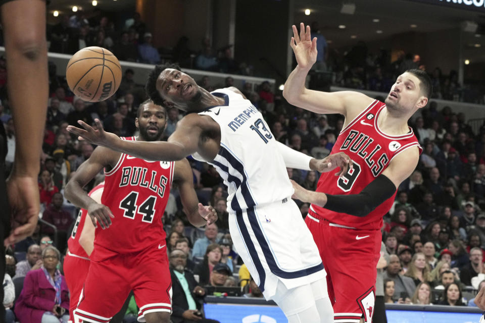 Memphis Grizzlies' Jaren Jackson Jr. reaches for the ball as Chicago Bulls' Nikola Vucevic (9) defends during the first half of an NBA basketball game Tuesday, Feb. 7, 2023, in Memphis, Tenn. (AP Photo/Karen Pulfer Focht)