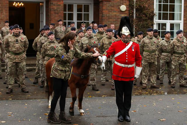 <p>CHRIS RADBURN/POOL/AFP via Getty Images</p> Kate Middleton promotes a pony mascot of the Queen's Dragoon Guards on Nov. 8, 2023
