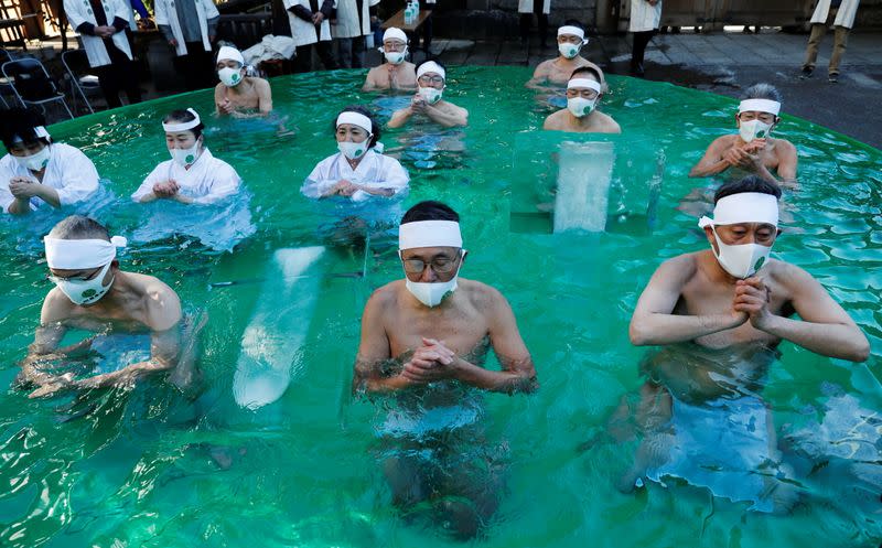 Participants wearing protective face masks amid the coronavirus disease (COVID-19) outbreak, take an ice-cold bath at a ceremony in Tokyo