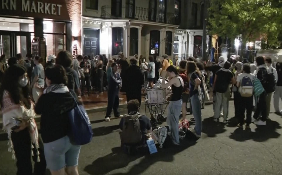 In this grab taken from video, protestors protesting the Israel-Hamas war stand outside near the campus of George Washington University, in Washington, Wednesday, May 8, 2024. Tensions have continued to ratchet up in standoffs with protesters on campuses across the U.S. and increasingly, in Europe, nearly three weeks into a movement launched by a protest at Columbia University. (WJLA via AP)