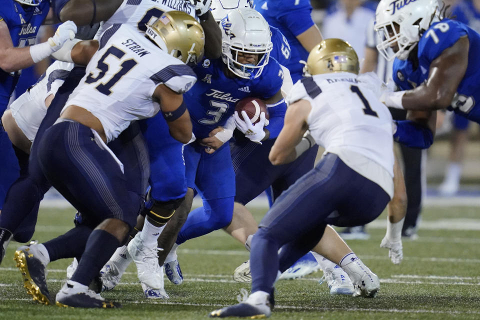 Navy linebackers Nicholas Straw (51) and John Marshall (1) move in to tackle Tulsa running back Shamari Brooks (3) in the first half of an NCAA college football game, Friday, Oct. 29, 2021, in Tulsa, Okla. (AP Photo/Sue Ogrocki)