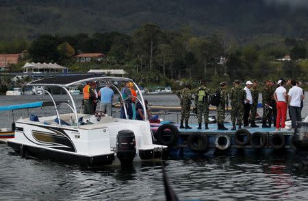 Rescuers wait at the dock after a tourist boat sank with 150 passengers onboard at the Guatape reservoir, Colombia, June 25, 2017. REUTERS/ Fredy Builes