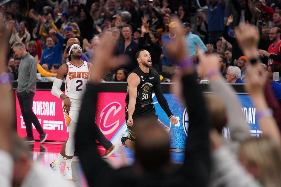 Golden State Warriors guard Stephen Curry (30) celebrates in front of Phoenix Suns guard Josh Okogie (2) after making a three-point shot in the fourth quarter at the Chase Center in San Francisco on March 13, 2023.