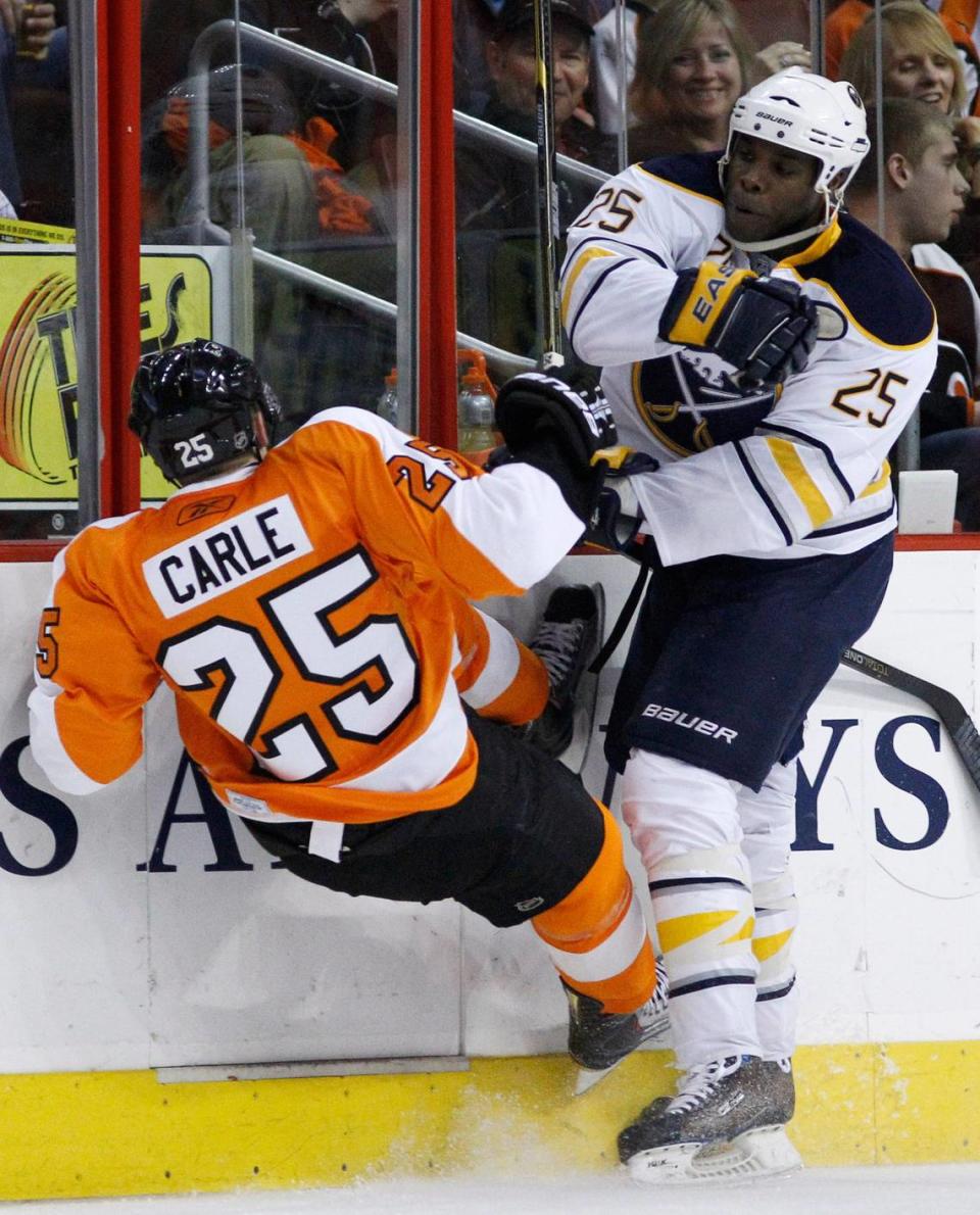 Philadelphia Flyers’ Matt Carle, left, is knocked down by Buffalo Sabres’ Mike Grier in the first period of Game 1 of a first-round NHL hockey playoff series, Thursday, April 14, 2011, in Philadelphia.