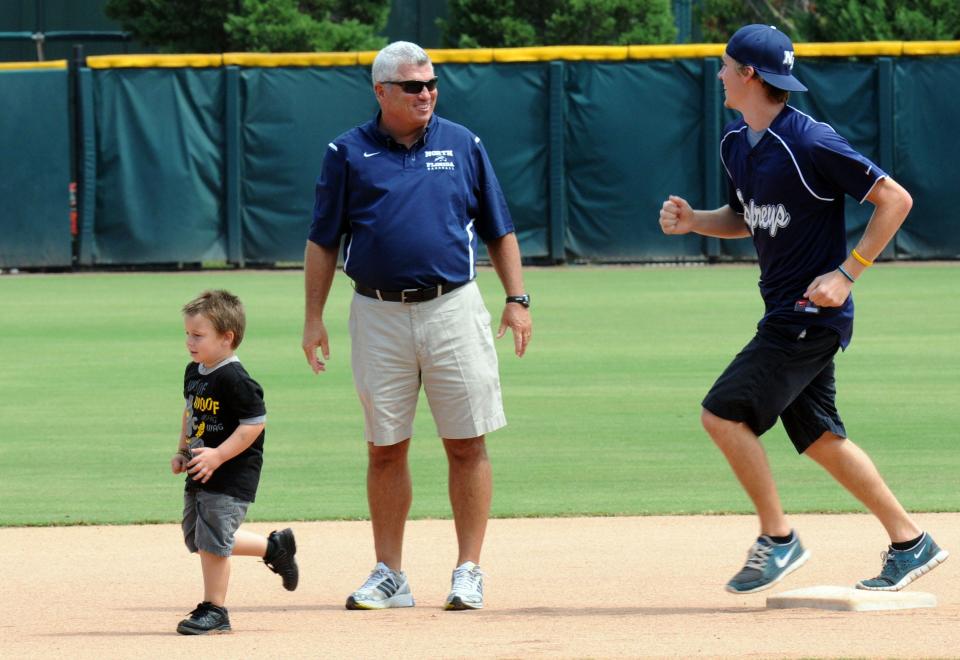 Tim Parenton (center) worked tirelessly in baseball camps and clinics. In a 2011 photo when he was an assistant at UNF, he and UNF player Nick Allbritton held Corey Metlin, 4 years old at the time, with his baserunning.