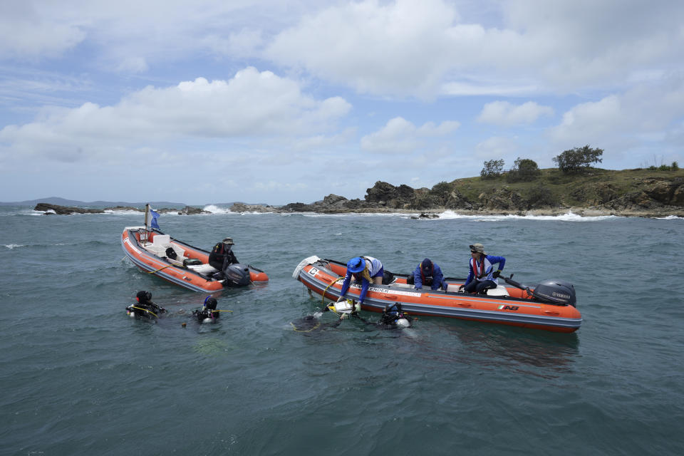 Scientists working for the Australian Institute of Marine Science gather corals for study off Konomie Island off the coast of Queensland in eastern Australia on Nov. 10, 2022. Authorities are trying to buy the reef time by combining ancient knowledge with new technology. (AP Photo/Sam McNeil)