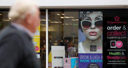 A woman walks past a branch of Superdrug in Loughborough, Britain. Aug 22, 2018. REUTERS/Darren Staples