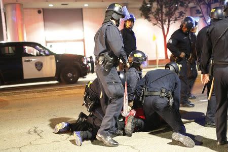 A police officer holds a baseball bat taken from a detained protester, during a demonstration following the grand jury decision on Monday in the Ferguson, Missouri, shooting of Michael Brown, in Oakland, California, November 26, 2014. REUTERS/Stephen Lam