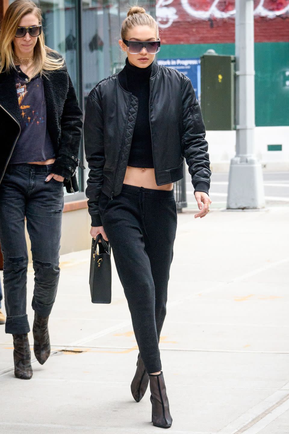 <p>In a black bomber jacket, cropped turlteneck top, low-rise sweatpants, transparent booties, black handbag and ombre sunglasses while out in NYC.</p>