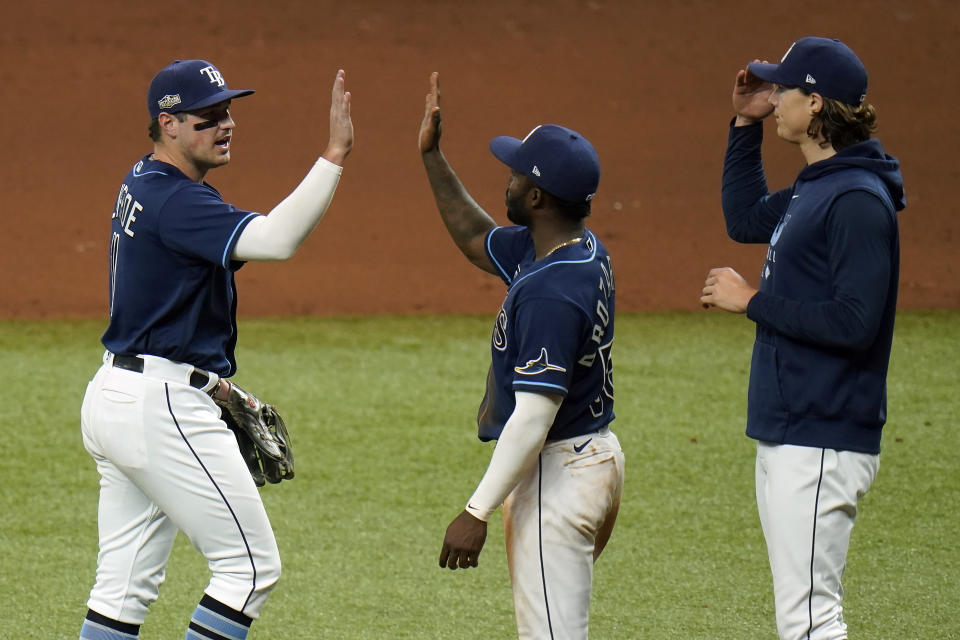 Tampa Bay Rays' Hunter Renfroe, left, celebrates with Randy Arozarena, center, and Tyler Glasnow after the Rays defeated the Toronto Blue Jays during Game 2 of an American League wild-card baseball series Wednesday, Sept. 30, 2020, in St. Petersburg, Fla. (AP Photo/Chris O'Meara)