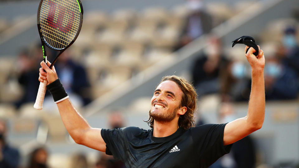 Seen here, Tsitsipas throws his arms up in triumph after his French Open quarter-final.