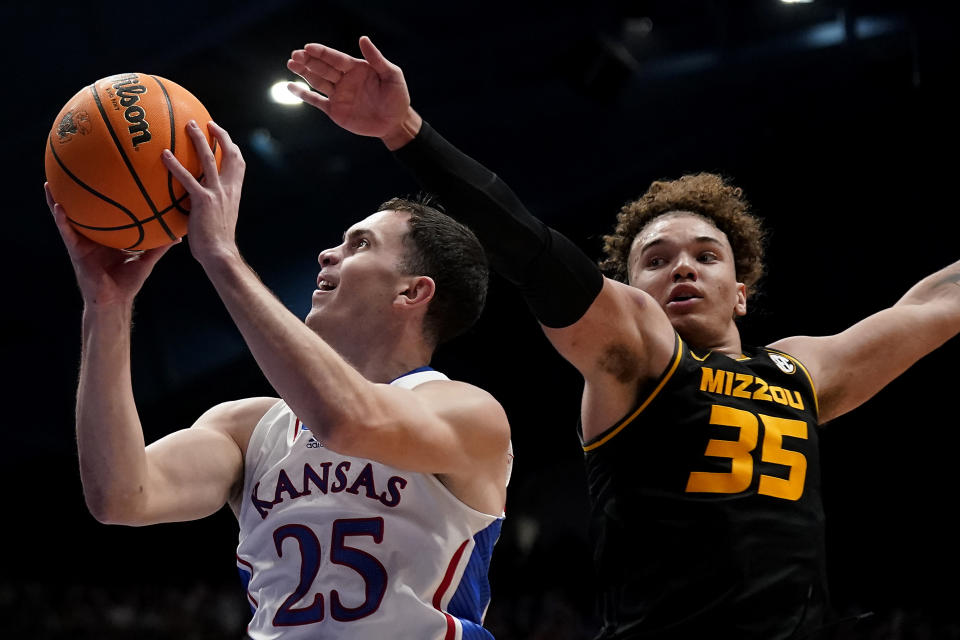 Kansas guard Nicolas Timberlake (25) shoots under pressure from Missouri forward Noah Carter (35) during the first half of an NCAA college basketball game Saturday, Dec. 9, 2023, in Lawrence, Kan. (AP Photo/Charlie Riedel)