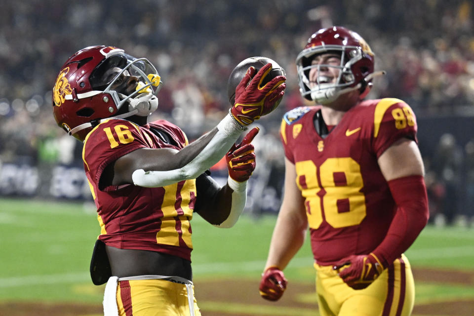 Southern California wide receiver Tahj Washington (16) celebrates a touchdown with tight end Kade Eldridge (88) during the first half of the Holiday Bowl NCAA college football game against Louisville Wednesday, Dec. 27, 2023, in San Diego. (AP Photo/Denis Poroy)