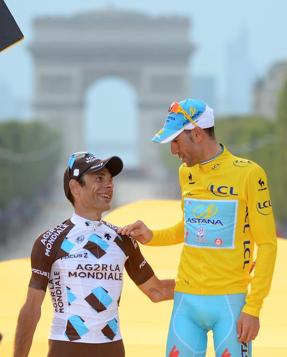 Race winner Vincenzo Nibali of Italy, wearing the overall leader's yellow jersey, chats witi second placed Jean-Christophe Peraud of France on the podium of the Tour de France in Paris, France, Sunday, July 27, 2014. (AP Photo/Jerome Prevost, Pool)