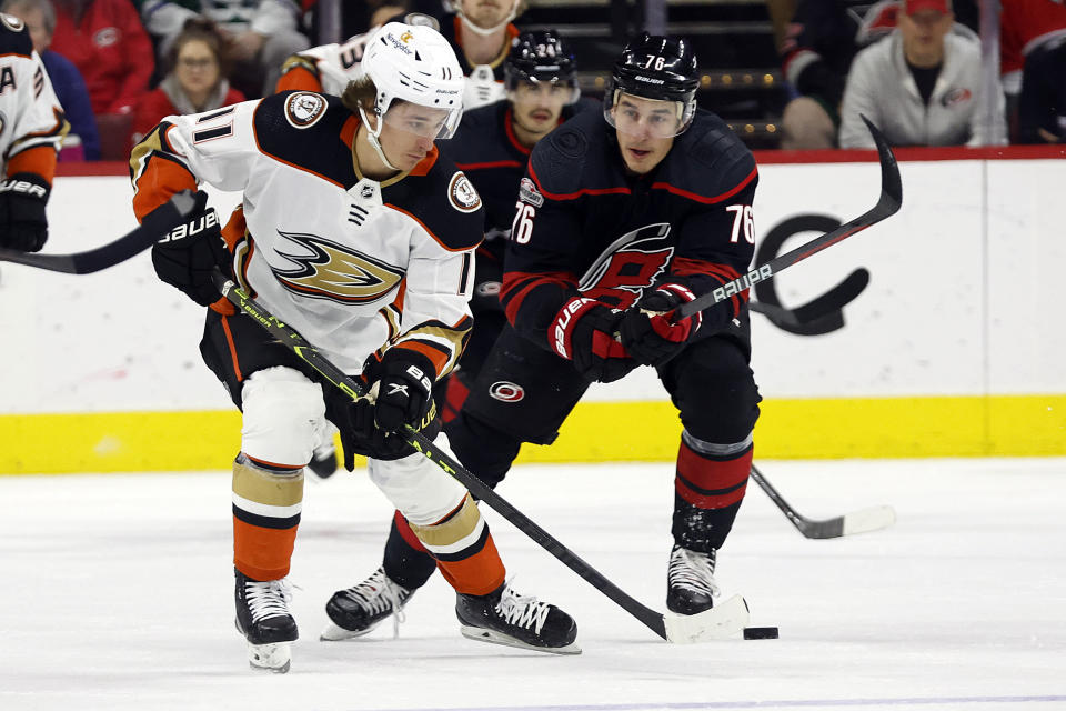 Anaheim Ducks' Trevor Zegras (11) controls the puck in front of Carolina Hurricanes' Brady Skjei (76) during the first period of an NHL hockey game in Raleigh, N.C., Saturday, Feb. 25, 2023. (AP Photo/Karl B DeBlaker)