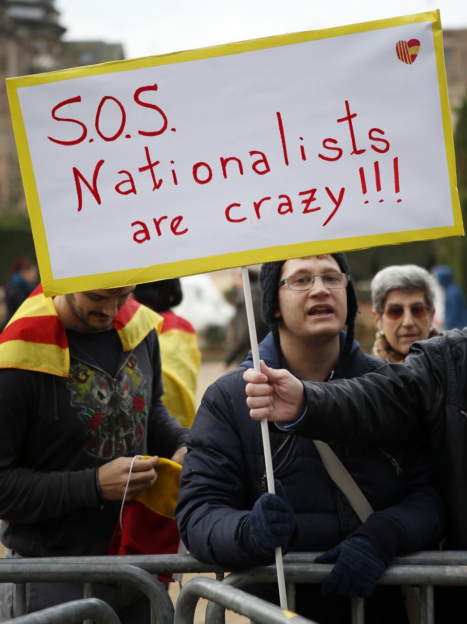 A demonstrator against independence for Catalonia holds a sign in front of Catalonia's regional parliament as lawmakers votes in Barcelona January 16, 2014. Local lawmakers in the north-eastern Spanish region of Catalonia voted to seek a referendum on breaking away from Spain on Thursday, setting themselves up for a battle with an implacably opposed central government in Madrid. The Catalan Parliament in Barcelona voted 87 to 43, with 3 abstentions, to send a petition to the national parliament seeking the power to call a popular vote on the region's future. REUTERS/Albert Gea (SPAIN - Tags: POLITICS CIVIL UNREST)