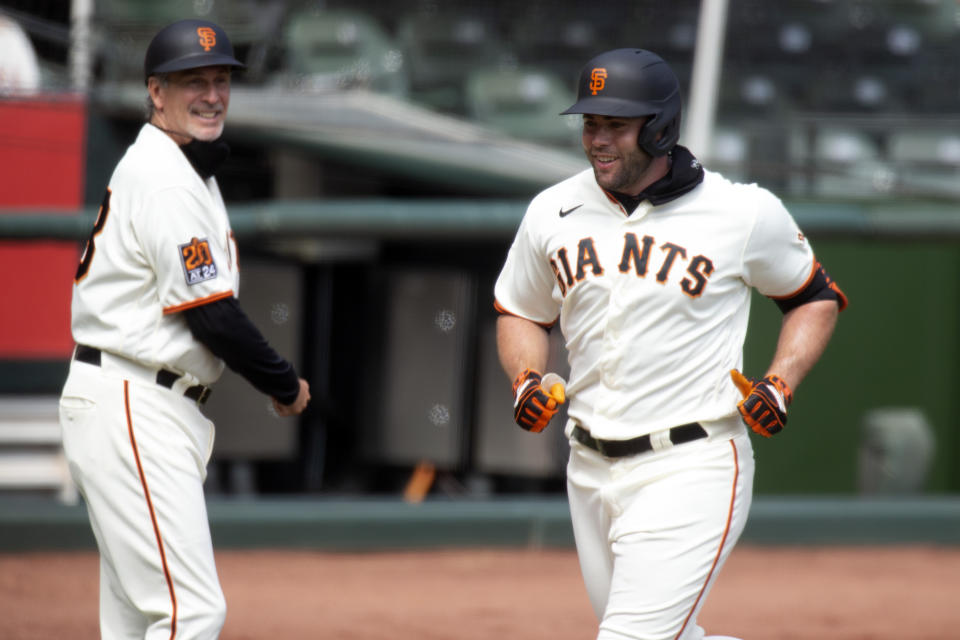 San Francisco Giants' Darin Ruf, right, runs out his solo home run during the second inning of a baseball game against the Seattle Mariners, Thursday, Sept. 17, 2020 in San Francisco. Third base coach Ron Wotus looks on. (AP Photo/D. Ross Cameron)