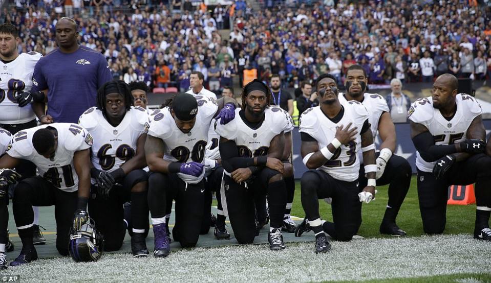 Baltimore Ravens players, including former star Ray Lewis (second right) kneel during the playing of the national anthem (AP)