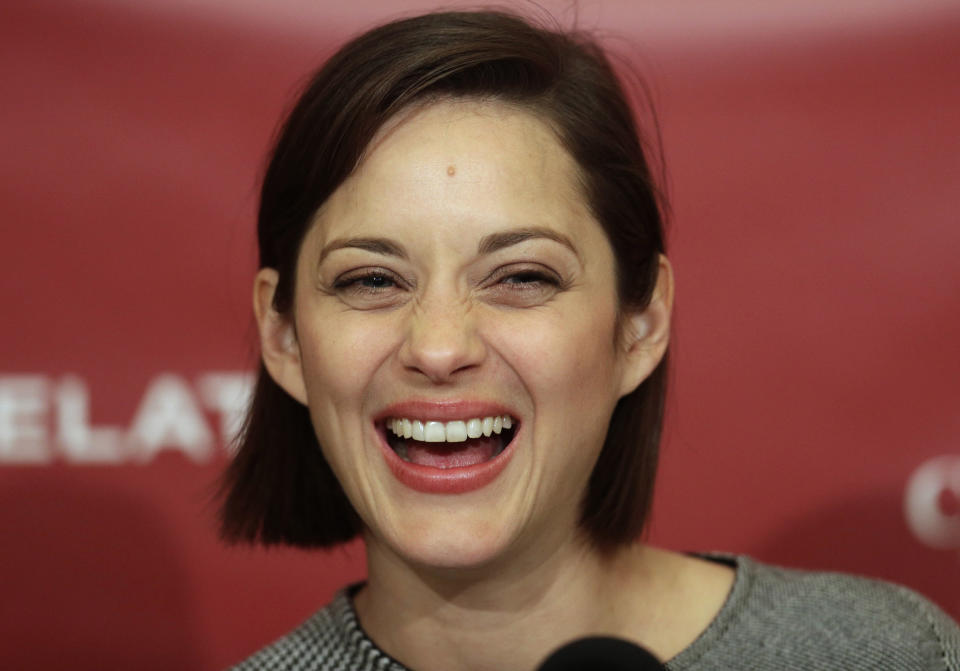 Hasty Pudding Woman of the Year, actress Marion Cotillard, of France, laughs during a news conference at Harvard University, in Cambridge, Mass., Thursday, Jan. 31, 2013. The award was presented to Cotillard by Hasty Pudding Theatricals, a theatrical student society at Harvard. (AP Photo/Steven Senne)