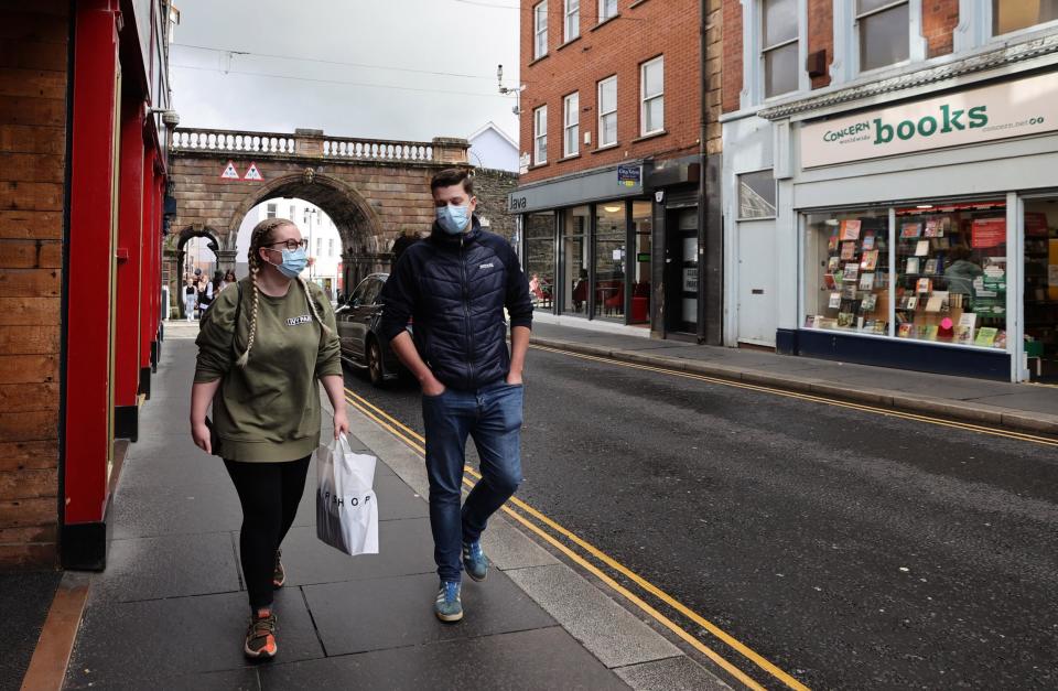 People walking along Ferryquay Street in Derry as Northern Ireland braced for new coronavirus measures to be enforced (PA)