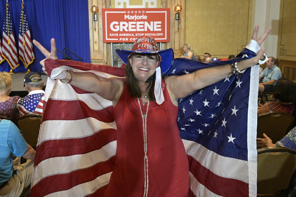 An attendee who only gave her name as Sherry dances in the crowd during a rally featuring Rep. Matt Gaetz, R-Fla. and Rep. Marjorie Taylor Greene, R-Ga., Friday, May 7, 2021, in The Villages, Fla. (AP Photo/Phelan M. Ebenhack)