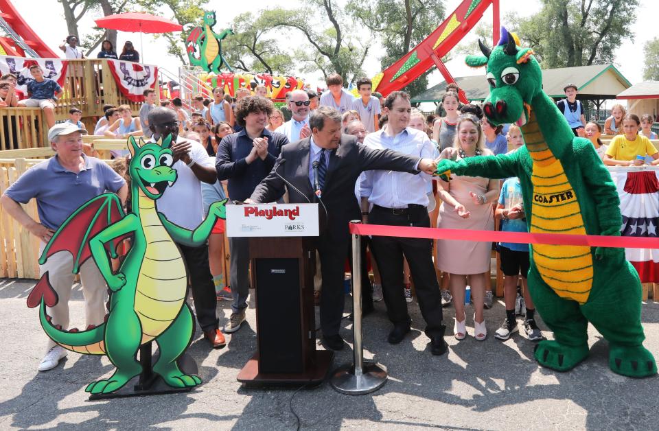 County Executive George Latimer fist bumps Coaster the Dragon at a press conference for the official opening of the "Dragonator" ride at Playland July 30, 2019 in Rye.