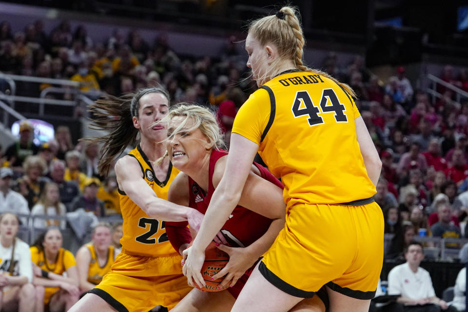 Nebraska center Alexis Markowski (40) fights for control of the ball with Iowa guard Caitlin Clark (22) and forward Addison O'Grady (44) in the first half of an NCAA college basketball game at the Big Ten Conference tournament in Indianapolis, Saturday, March 5, 2022. (AP Photo/Michael Conroy)