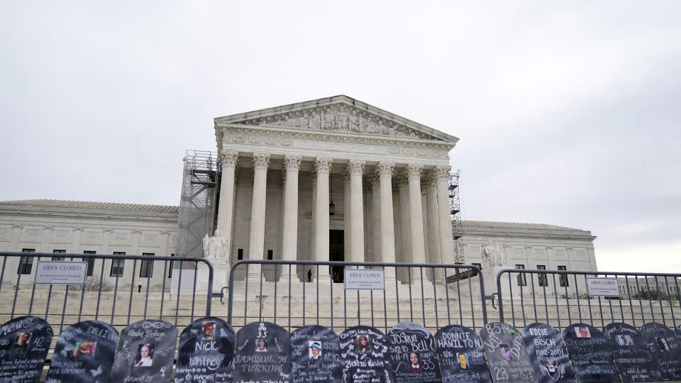 Signs in the shape of grave headstones, with information on people who died from using OxyContin, line a security fence outside the Supreme Court Monday, Dec. 4, 2023, in Washington, DC. - Stephanie Scarbrough/AP