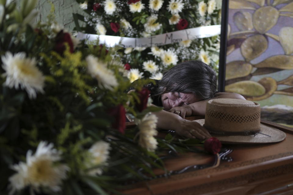 Olivia Mora cries over the casket of her brother Hipolito Mora during his wake at his home in La Ruana, Mexico, Friday, June 30, 2023. Hipolito Mora, the leader of an armed civilian movement that once drove a drug cartel out of the western state of Michoacan, was killed Thursday on a street in his hometown. (AP Photo/Eduardo Verdugo)