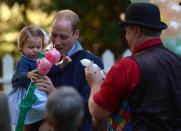 Prince William holds Princess Charlotte, as she is given a balloon animal during a children’s tea party at Government House in Victoria, Thursday, Sept. 29, 2016. THE CANADIAN PRESS/Jonathan Hayward