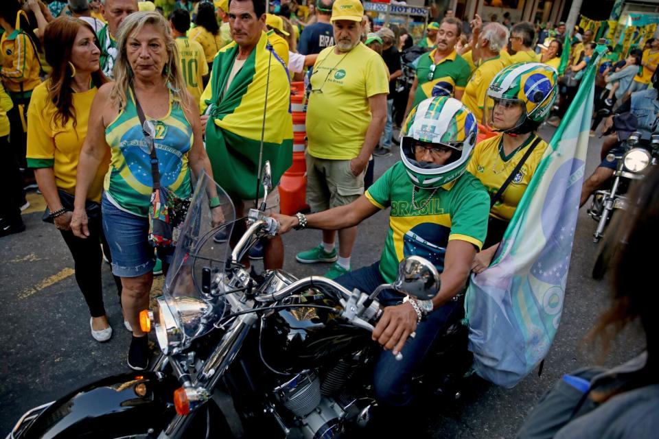 Supporters of the president line the street.