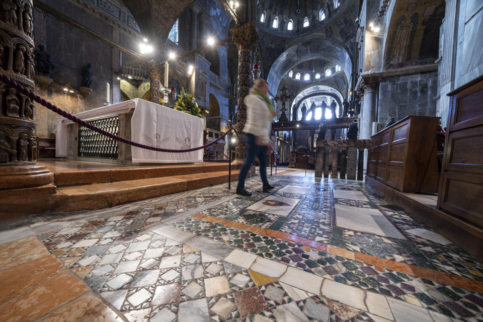 People walk on the fragile marble mosaics on the floor of St. Mark's Basilica in Venice, northern Italy, Wednesday, Dec. 7, 2022. Glass barriers that prevent seawater from flooding the 900-year-old iconic St Mark's Basilica during high tides have been recently installed around it. St. Mark's Square is the lowest-laying city area and frequently ends up underwater during extreme weather. (AP Photo/Domenico Stinellis)