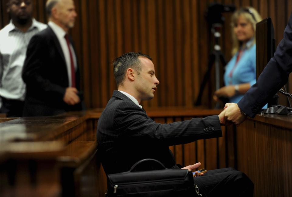 Olympic and Paralympic track star Oscar Pistorius sits in the dock during court proceedings at the North Gauteng High Court in Pretoria March 18, 2014. Pistorius is on trial for murdering his girlfriend Reeva Steenkamp at his suburban Pretoria home on Valentine's Day last year. REUTERS/Werner Beukes/Pool (SOUTH AFRICA - Tags: SPORT CRIME LAW ATHLETICS)