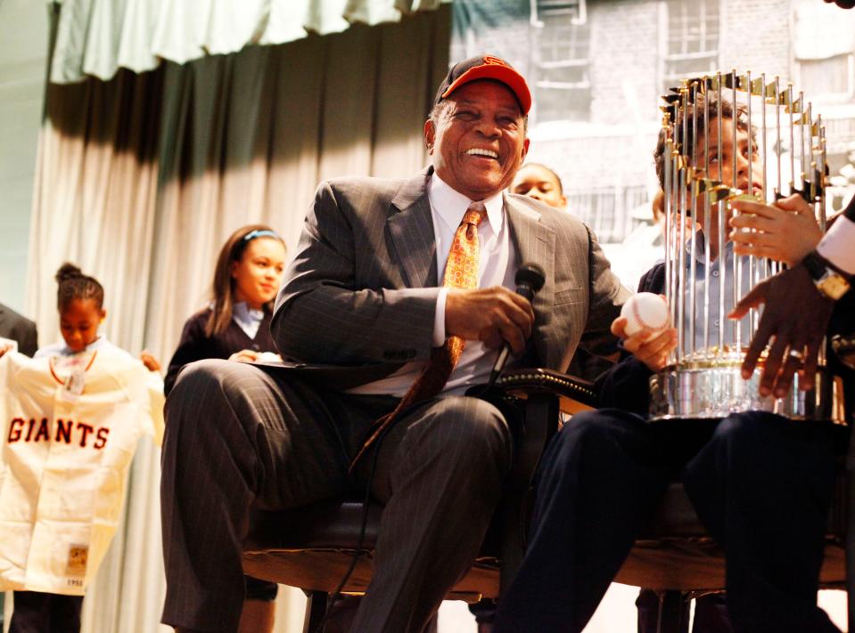 Willie Mays smiles while a student from PS 46 the Arthur Tappan School sits with the World Series trophy in New York, Jan. 21, 2011. The school is located in the Polo Grounds neighborhood where the Giants and Mays played before moving to San Francisco in 1958.