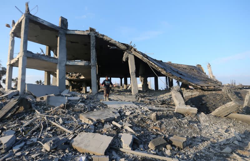 Palestinian man inspects a destroyed wedding hall after being attacked by Israeli aircrafts, in Gaza