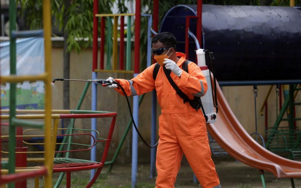 A government official sprays disinfectant at a kindergarten school in Banda Aceh, Indonesia - HOTLI SIMANJUNTAK/EPA-EFE/Shutterstock