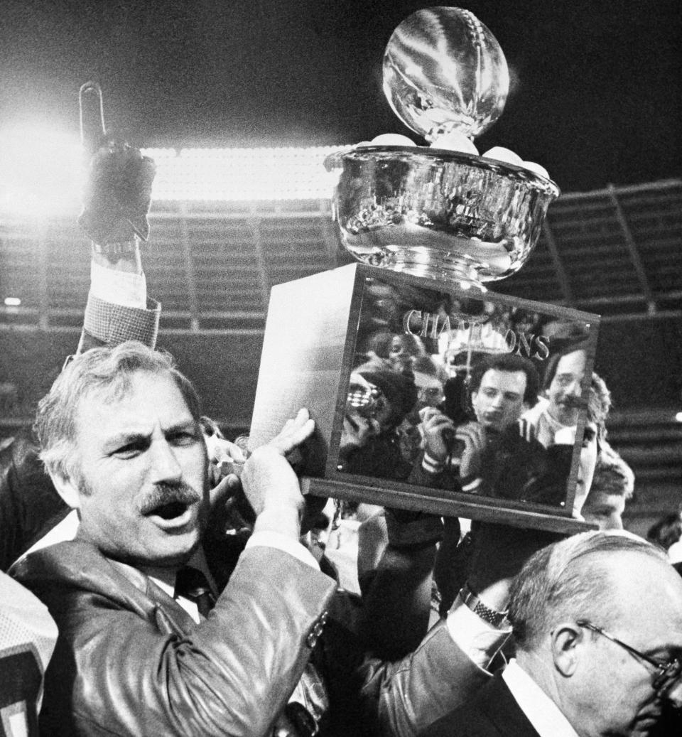 University of Miami coach Howard Schnellenberger holds the 1981 Peach Bowl trophy aloft after his team defeated Virginia Tech. (AP Photo/Joe Sebo)