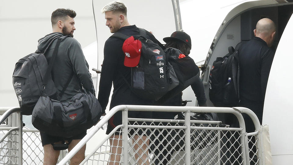 Essendon Bombers players, pictured here boarding a flight out of Melbourne Airport.