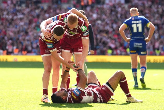 Wigan's players embrace celebrating their Challenge Cup victory