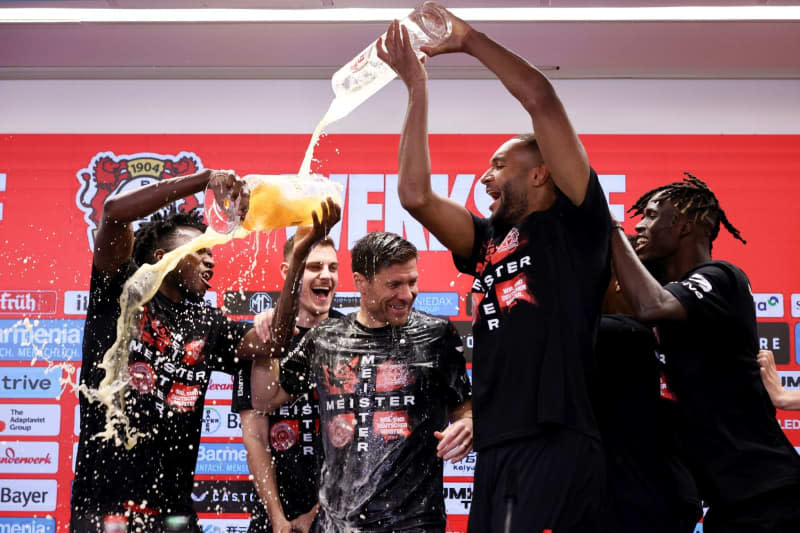 Leverkusen coach Xabi Alonso is doused with beer by his players at the post-match press conference following the German Bundesliga soccer match between Bayer 04 Leverkusen and SV Werder Bremen at BayArena. Rolf Vennenbernd/dpa