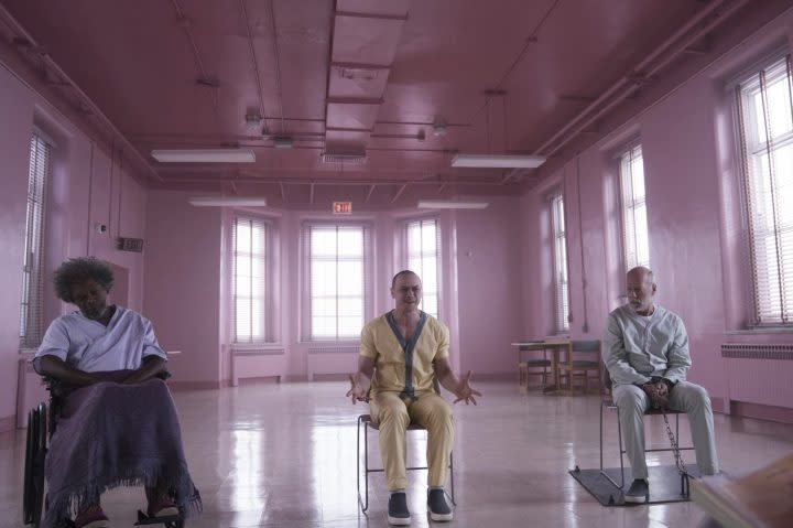 Three men sit in chairs as they face a doctor.