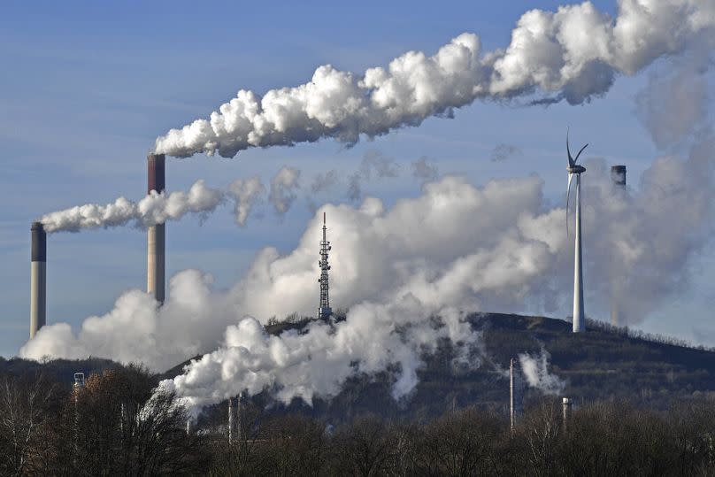 A coal-fired power plant and a refinery steam beside a wind generator in Gelsenkirchen, January 2020