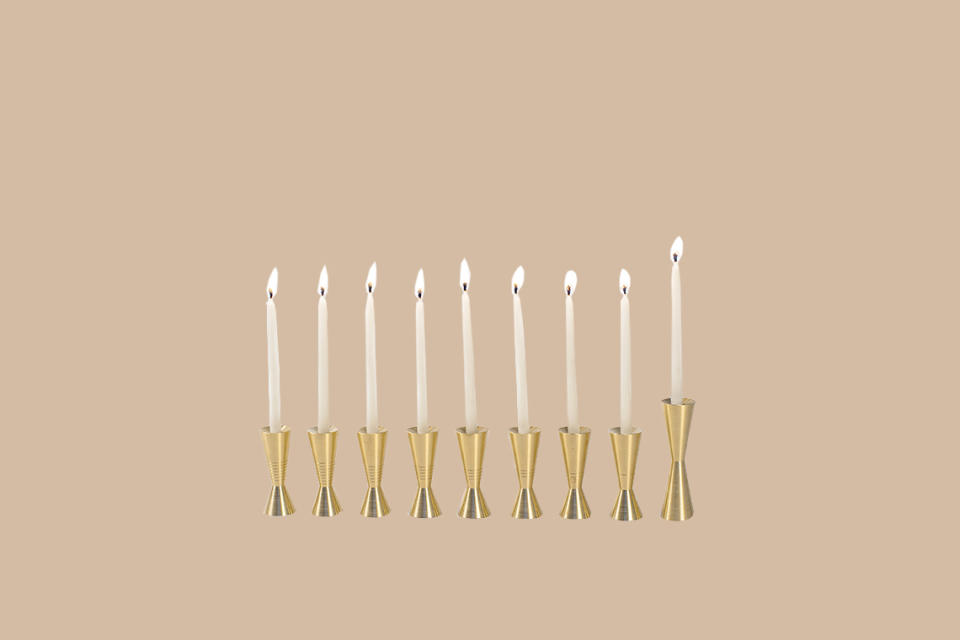 <p>Count the days of Hanukkah in style with this set of nine individual candle holders—each one is scored to signify the passing nights and feature a reclaimed leather base for traction and tapered top to collect dripping wax. Due to their modular shapes, they can be configured to fit almost any tabletop space. Over the years, the brass will take on a beautiful patina.</p><p><em>Avandi Counting Menorah, $425, </em><a href="http://www.avandistudio.com/shop/counting-menorah" rel="nofollow noopener" target="_blank" data-ylk="slk:avandistudio.com;elm:context_link;itc:0;sec:content-canvas" class="link "><em>avandistudio.com</em></a><em>.</em></p>