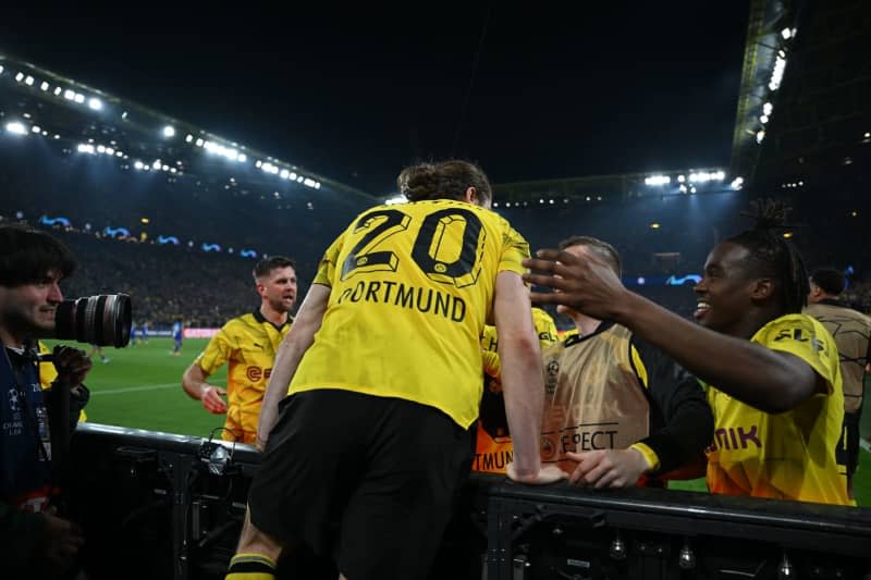 Dortmund's Marcel Sabitzer (C) returns to the pitch after celebrating scoring his side's fourth goal during the UEFA Champions League quarter-finals, second leg soccer match between Borussia Dortmund and Atletico Madrid at Signal Iduna Park. Bernd Thissen/dpa