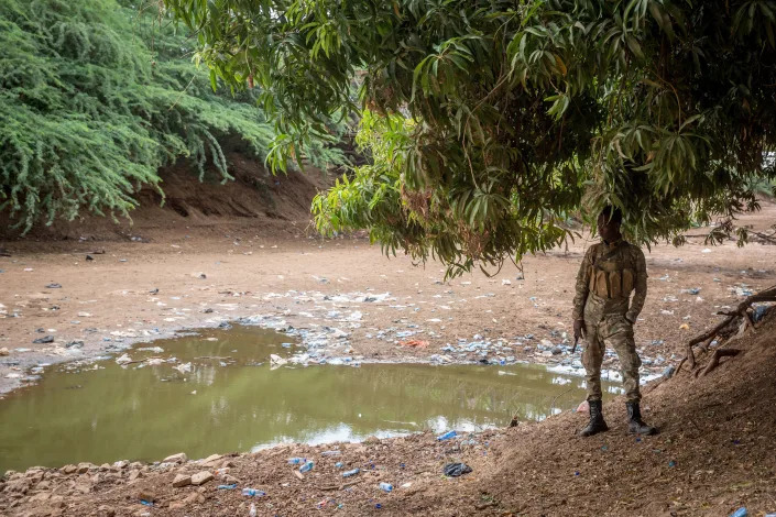 A soldier stands in front of the dried up Jubba River