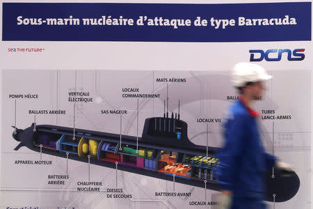 An employee walks past a poster showing a Barracuda submarine at the industrial site of the naval defence company and shipbuilder DCNS in La Montagne near Nantes, France, April 26, 2016. REUTERS/Stephane Mahe/File Photo